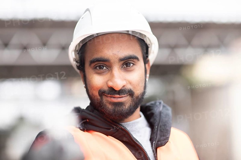 Technician with beard and helmet works in a workshop