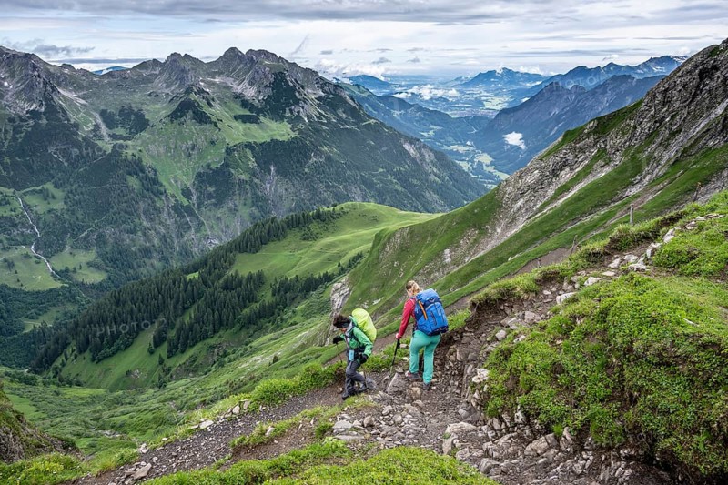 Two hikers descending on a hiking trail