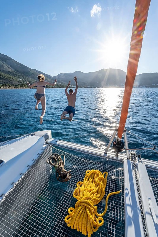 Young woman and young man jumping into the water