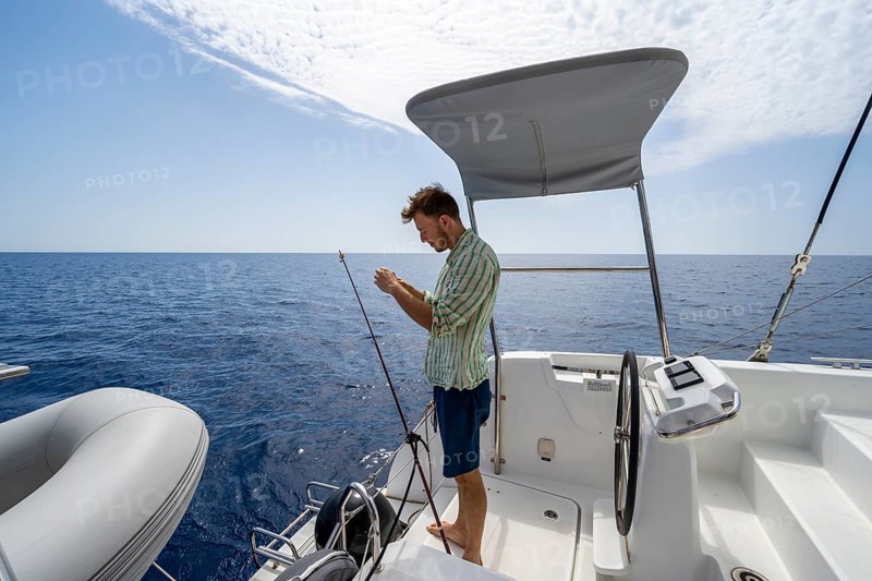 Young man fishing on a boat