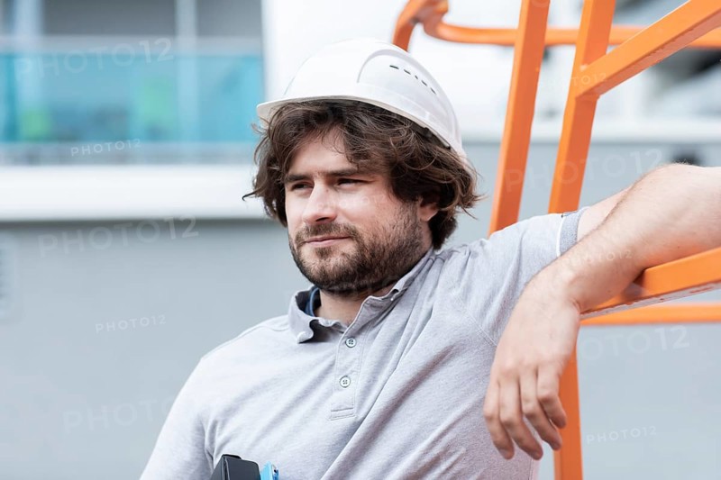 Technician with beard middle aged and working outside with polo shirt and helmet