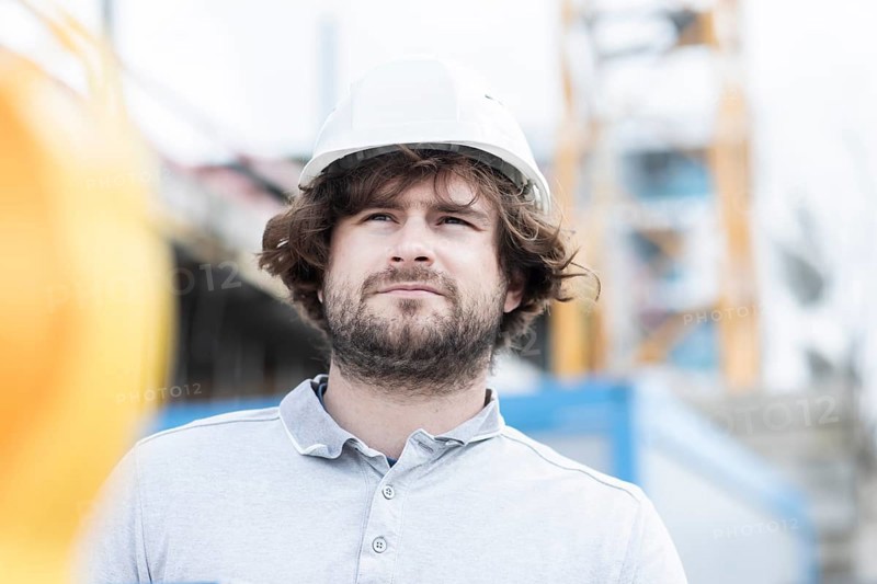 Technician with beard middle aged and working outside with polo shirt and helmet