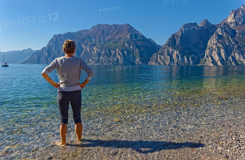 Hiker with footbath to cool down in Lake Garda