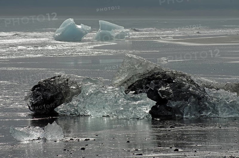 Pieces of ice lying on wide black beach