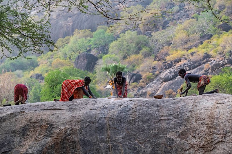 Young girls grinding Sorghum on a rock