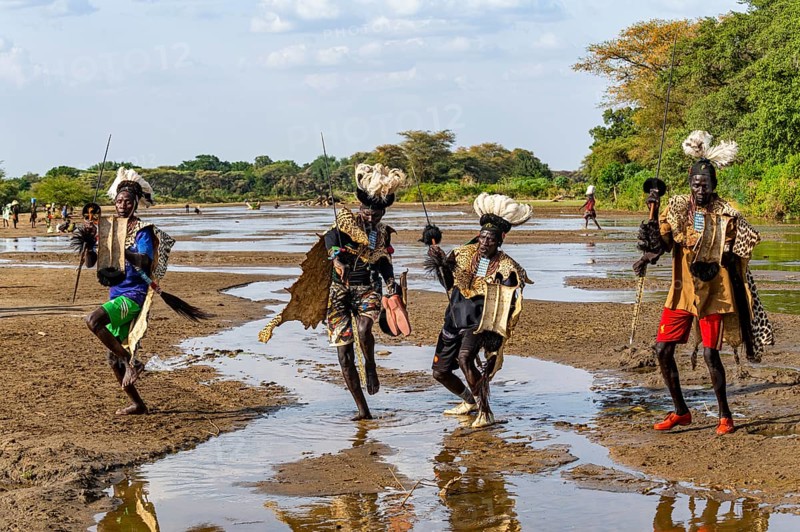 Men from the Toposa tribe posing in their traditional warrior costume