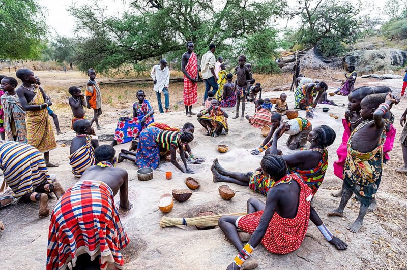 Young girls grinding Sorghum on a rock