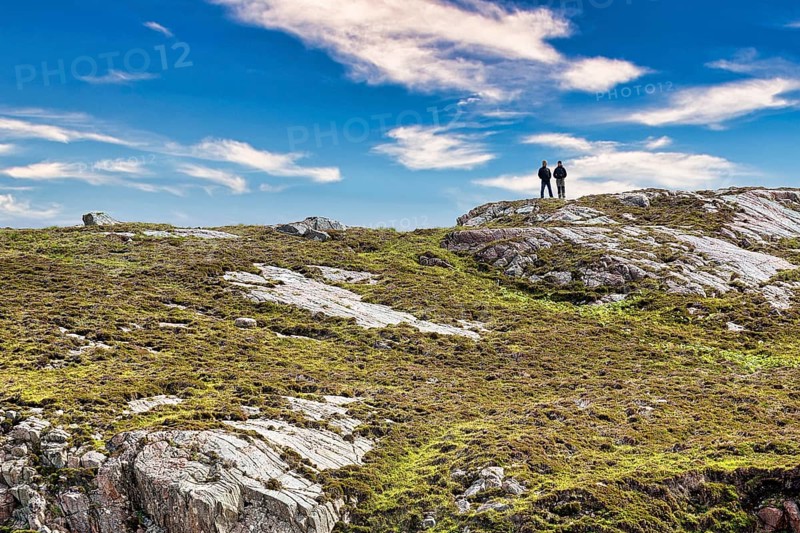 Walkers on rocky coast