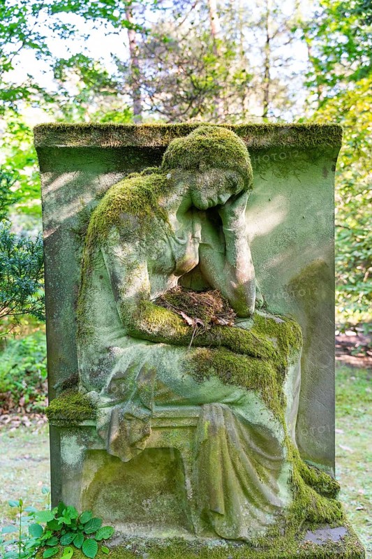 Grave sculpture with bird's nest in the lap