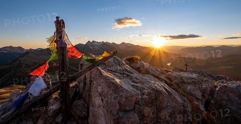Prayer flags and summit cross on Monte Castellaz at sunset