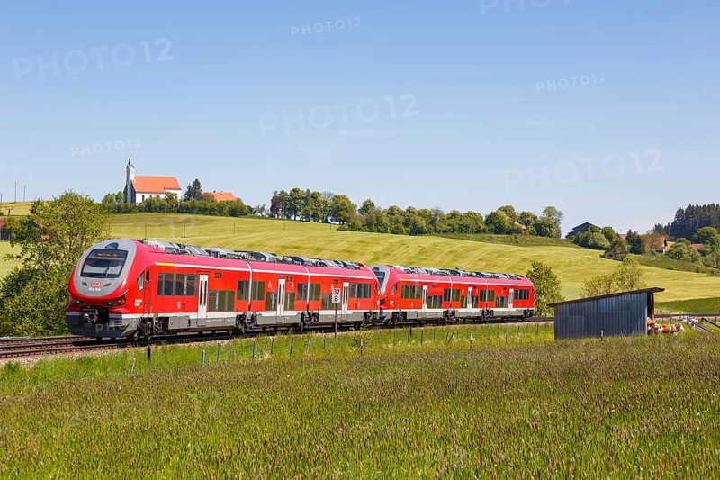 Pesa Link Regional train of Deutsche Bahn DB with church St. Alban in Allgaeu Bavaria in Aitrang