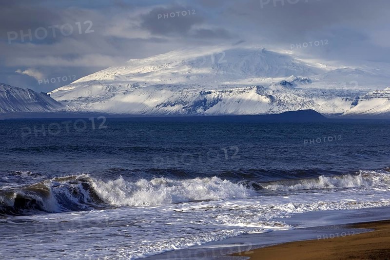 Beach with surf and the volcano and glacier Snaefellsjoekull