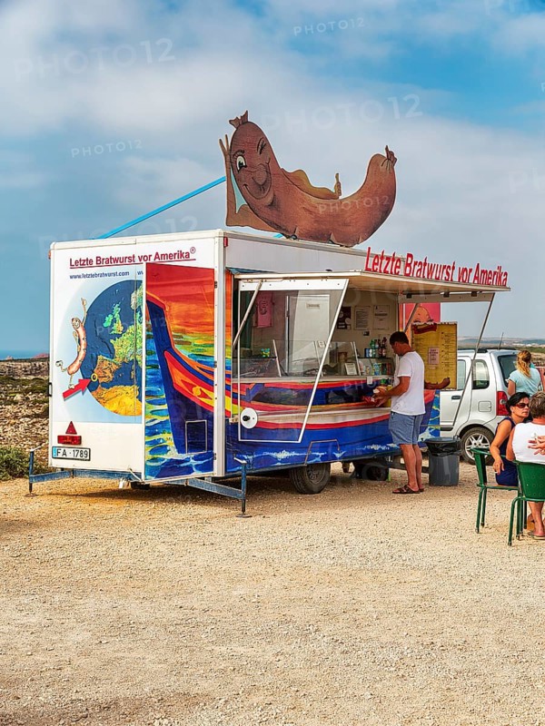Customers at the food stall labelled Last Bratwurst in front of America