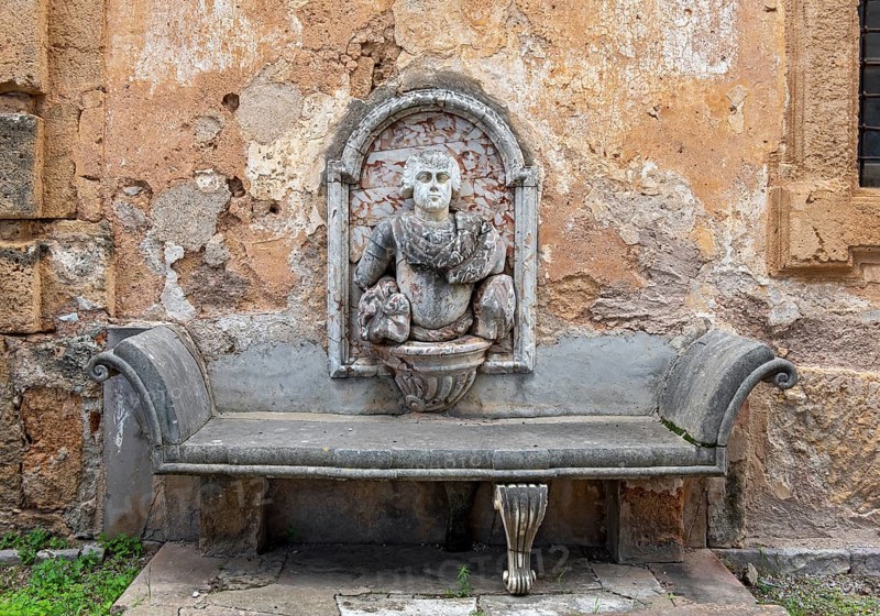 Stone bench with wall relief