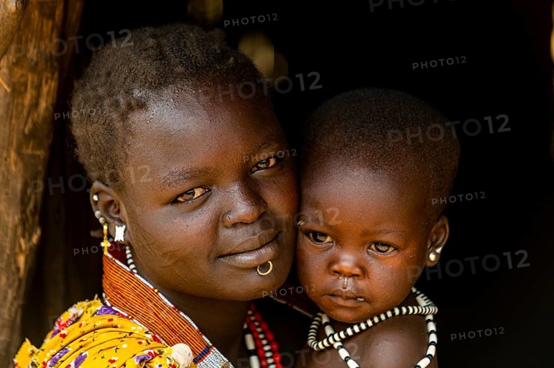 Woman with her baby sitting in a hut