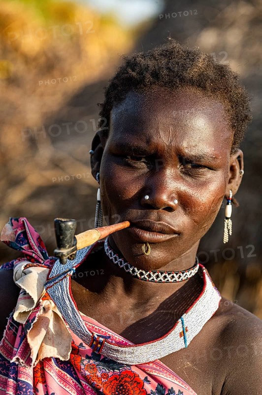 Woman from the Toposa tribe smoking a pipe
