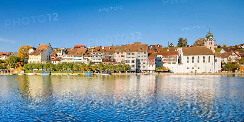 View from the banks of the Rhine over the Rhine towards the old town of Eglisau with reflection on the river water