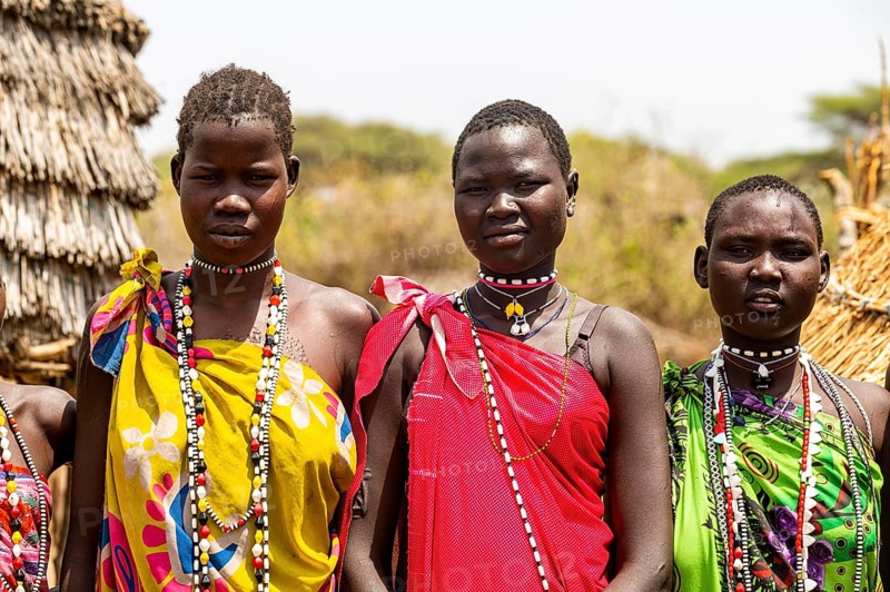 Traditional dressed girls from the Toposa tribe sitting in a grain storage