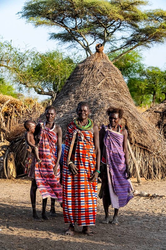 Older women from the Toposa tribe before their traditional hut
