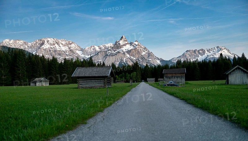 Path and meadow with hay barns