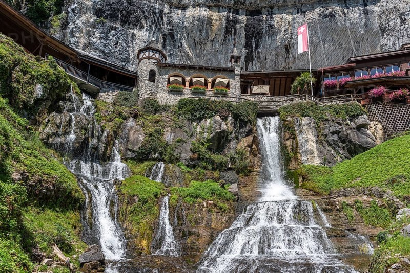 Ensemble of buildings with waterfall in front of the Saint Beatus Caves