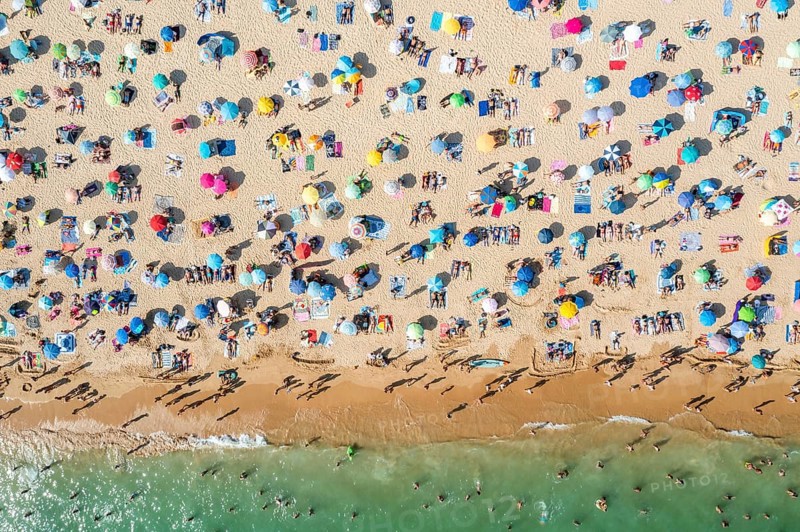 Drone shot of people enjoying the beach and the ocean