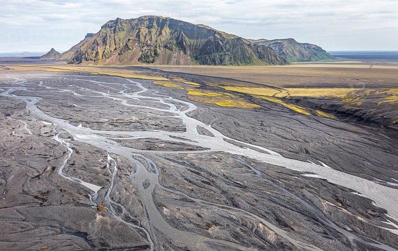 River with fanned out branches through black lava sand