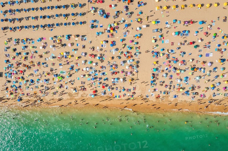 Drone shot of people enjoying the beach and the ocean