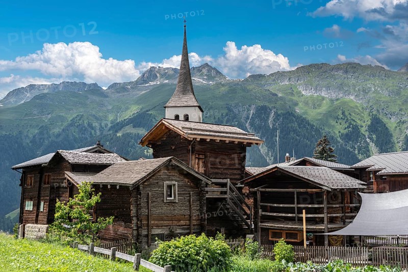 Historic village centre with wooden Valais houses and tower of the Seven Joys of Mary parish church