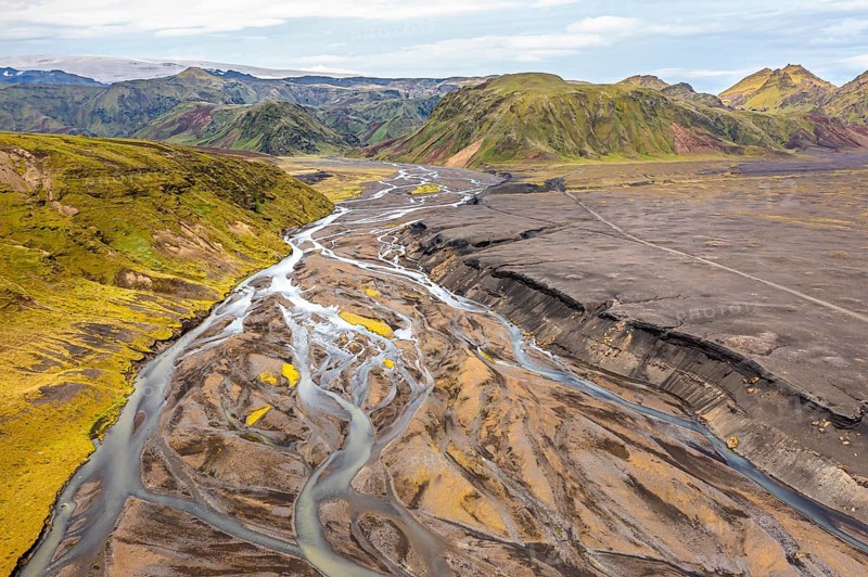 River with fanned out branches through black lava sand