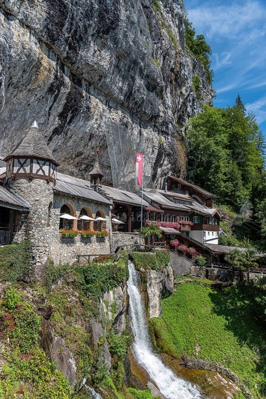 Ensemble of buildings with waterfall in front of the Saint Beatus Caves
