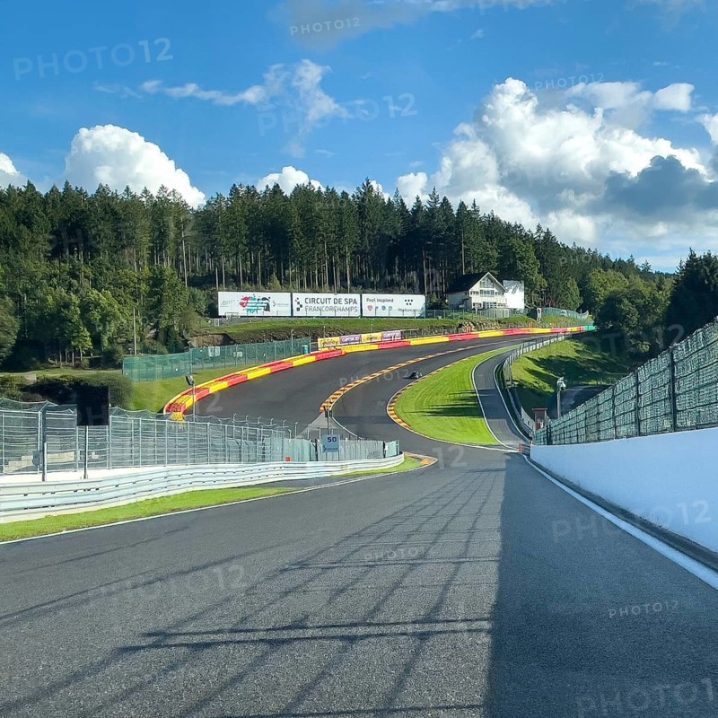 View from a moving race car onto the Eau Rouge bend and Raidillon slip road of the Circuit de Spa-Francorchamps