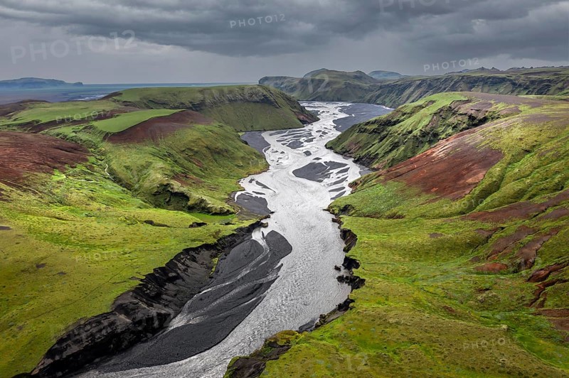 River with fanned out branches through black lava sand