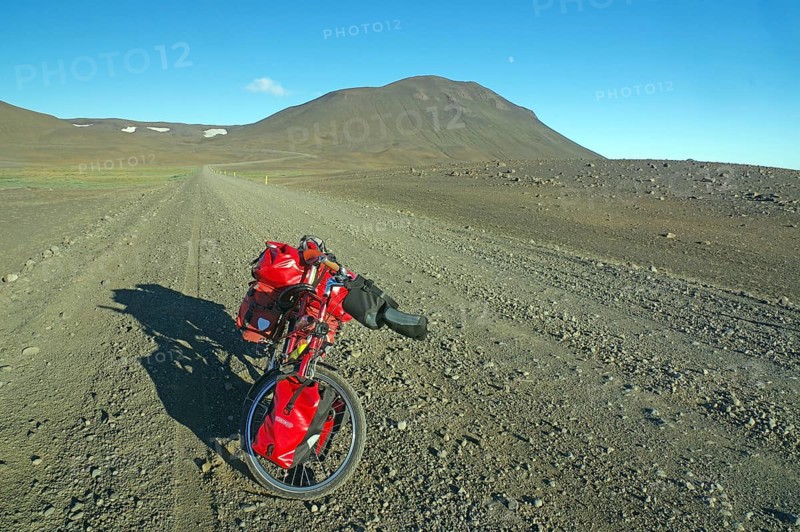 Loaded bicycle on rough track in barren