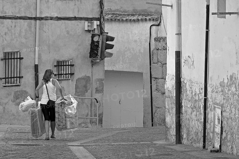 Woman carrying objects through alley in Cuenca