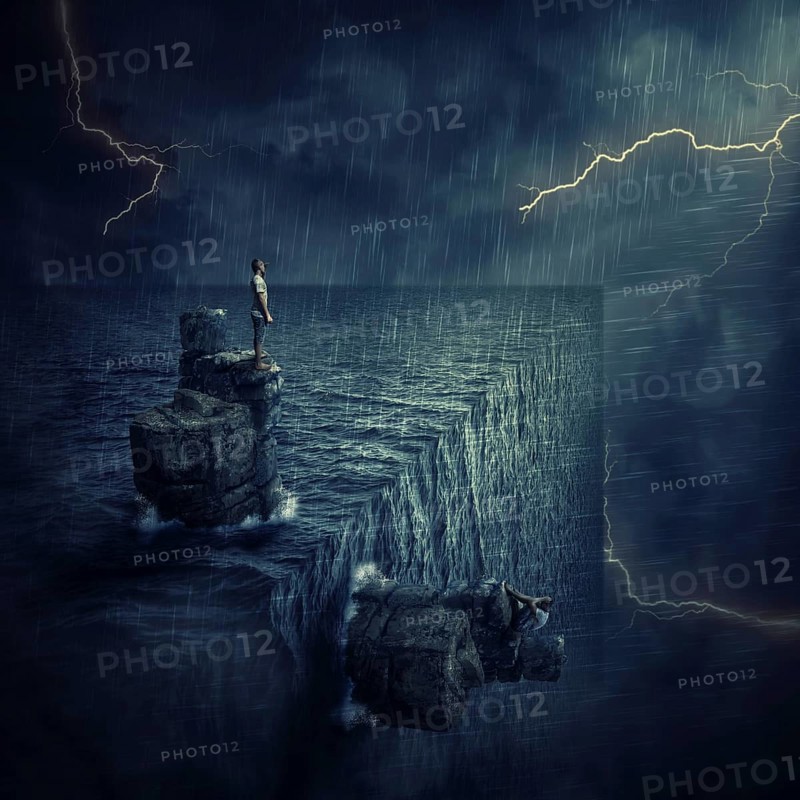 Conceptual image with a lost man sitting on a rock cliff island