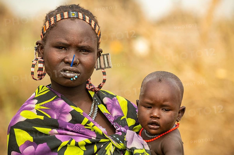 Woman with her child before her hut