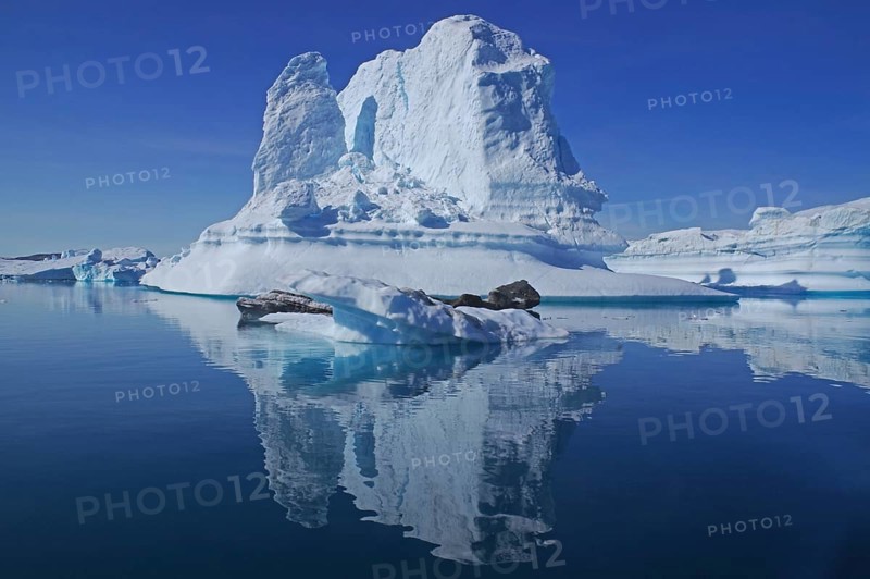 Huge iceberg reflected in a fjord