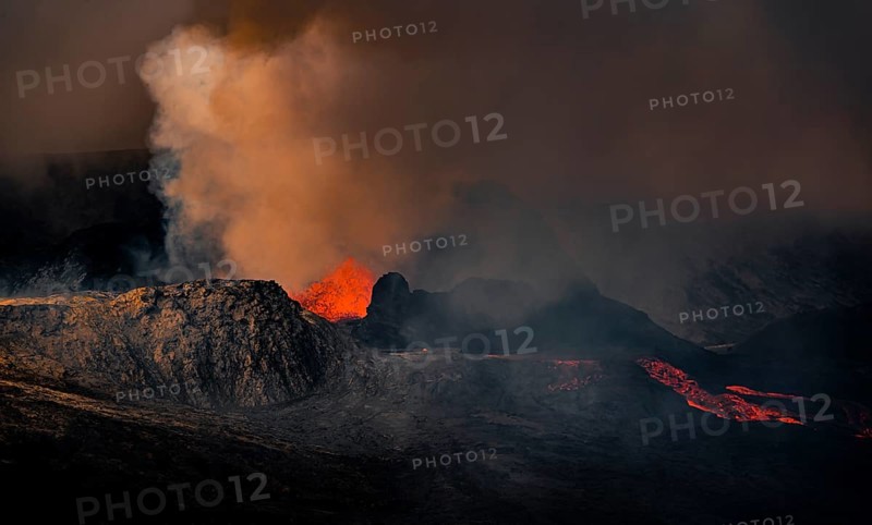 Erupting volcano with lava fountains and lava field