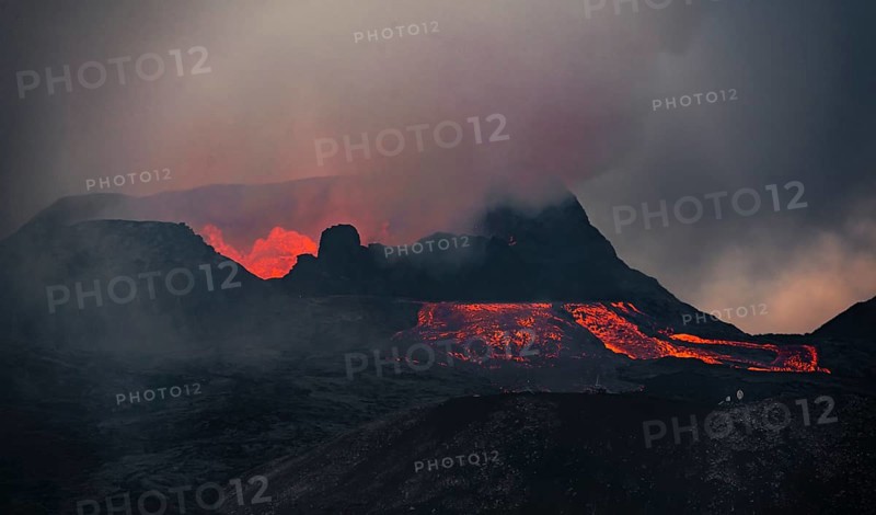 Erupting volcano with lava fountains and lava field