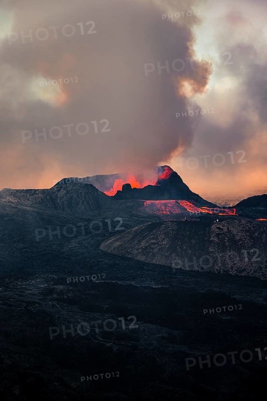 Erupting volcano with lava fountains and lava field