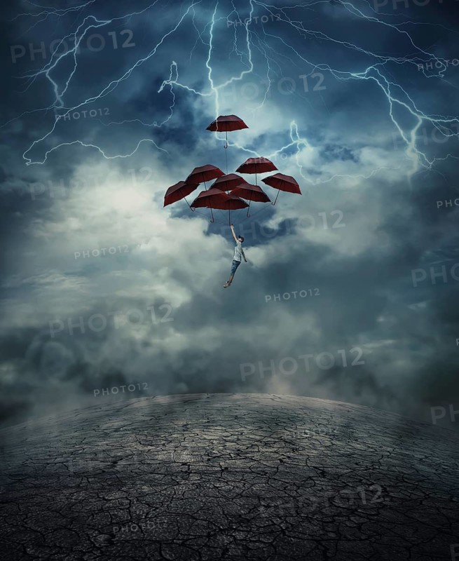 Young man with a lot of umbrellas as an air balloon rise up to the sky full of lightnings