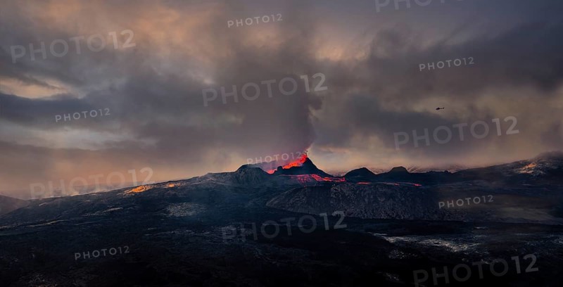 Erupting volcano with lava fountains and lava field