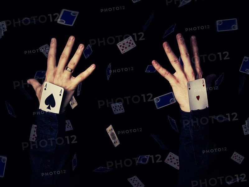 Close up of two human hands holding aces playing cards in the sleeve