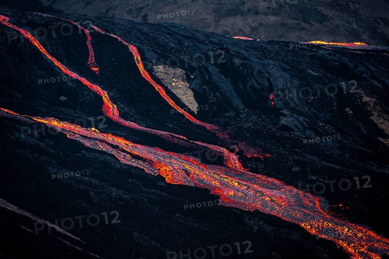 Erupting volcano with lava fountains and lava field