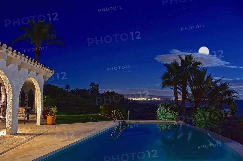 Villa with pool at night with full moon