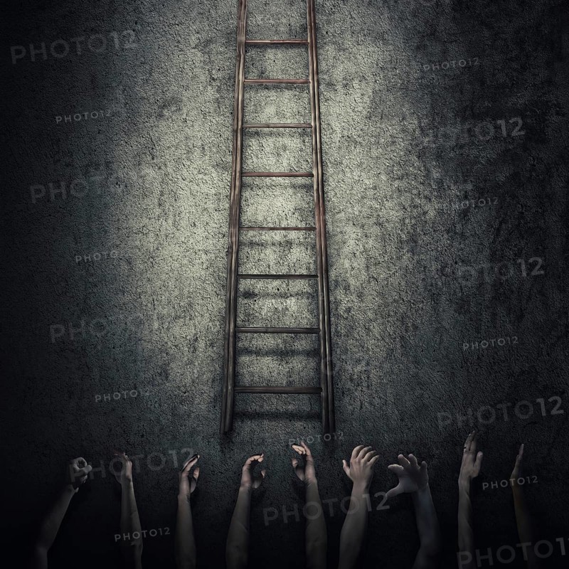 Abstract idea concept as a lot of human hands stretched out to reach a ladder and escape from a dark room prison