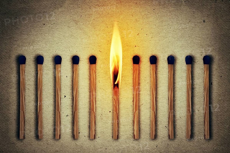 Burning match standing middle a row of whole