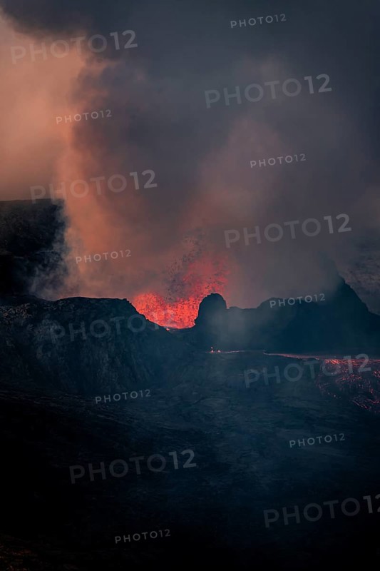 Erupting volcano with lava fountains and lava field