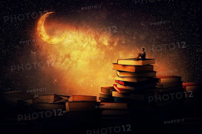 Boy sitting alone on a pile of books
